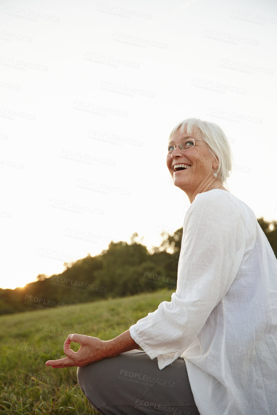 Buy stock photo Shot of an attractive mature woman doing yoga in nature