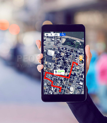 Buy stock photo Shot of a hand holding a smartphone showing gps data with a street as background