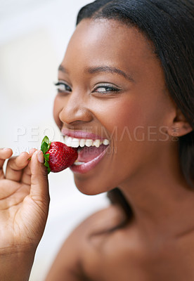 Buy stock photo Shot of a beautiful young woman eating strawberries