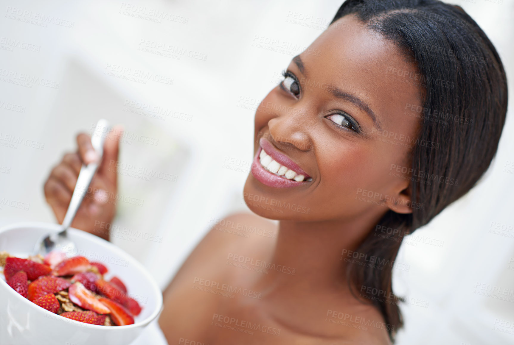 Buy stock photo Shot of a beautiful young woman eating strawberries