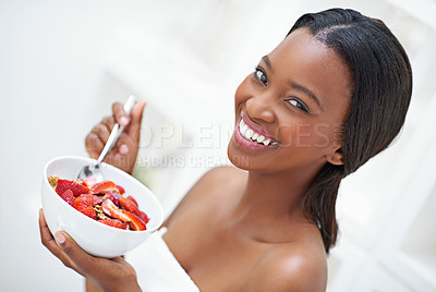 Buy stock photo Shot of a beautiful young woman eating a bowl of strawberriesff