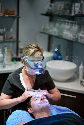 Buy stock photo Shot of a man getting a facial treatment at a beauty clinic