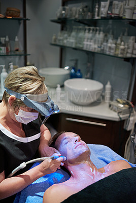 Buy stock photo Shot of a man getting a non-invasive face lift at a beauty clinic