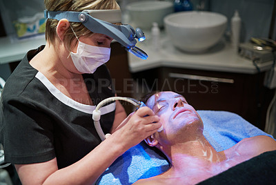 Buy stock photo Shot of a man getting a non-invasive face lift at a beauty clinic