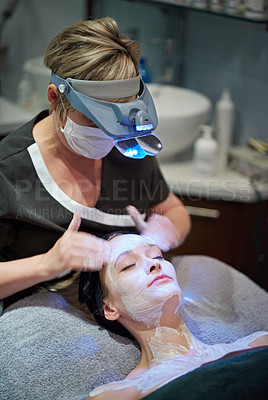 Buy stock photo Shot of a woman getting a facial treatment at a clinic