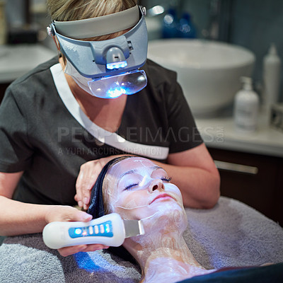 Buy stock photo Shot of a woman getting a non-invasive face lift at a beauty clinic