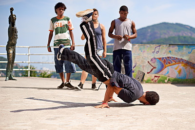 Buy stock photo Shot of a group of young people watching a breakdancer in the streets