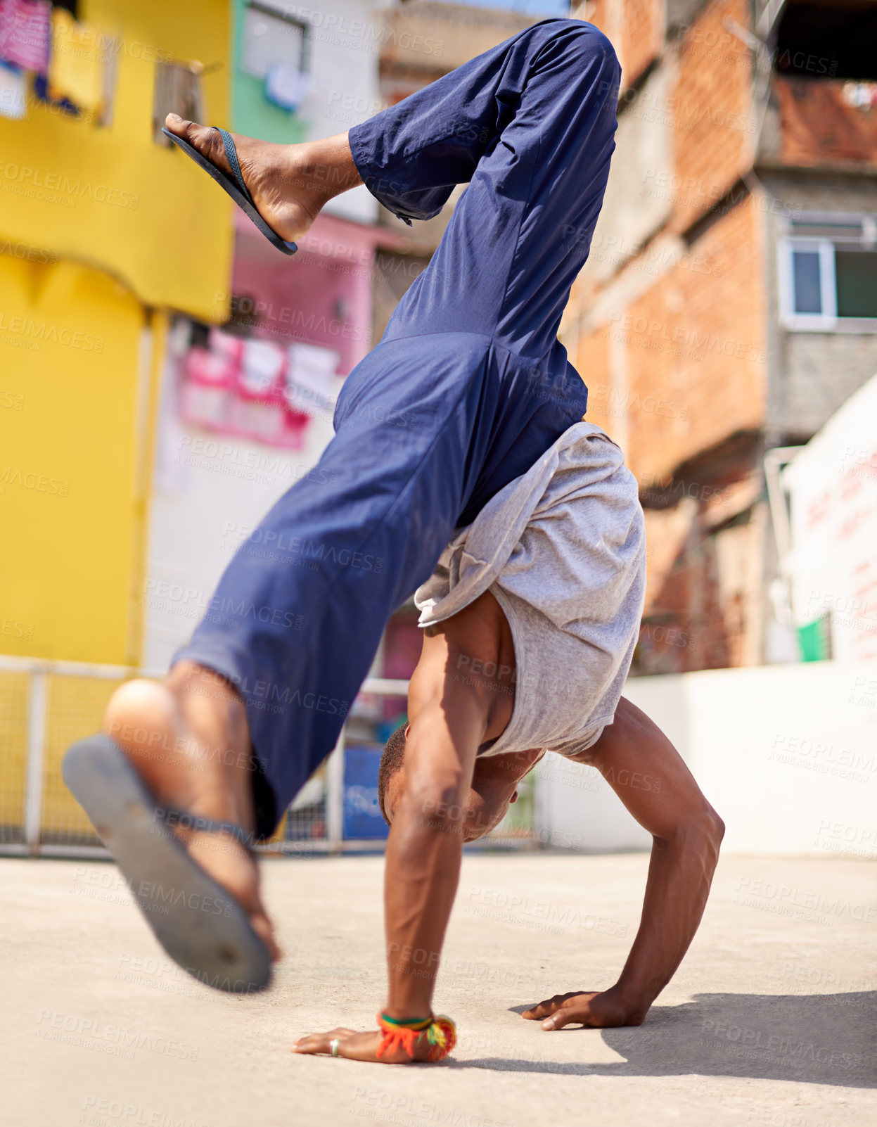 Buy stock photo Low angle shot of a young male breakdancer in an urban setting