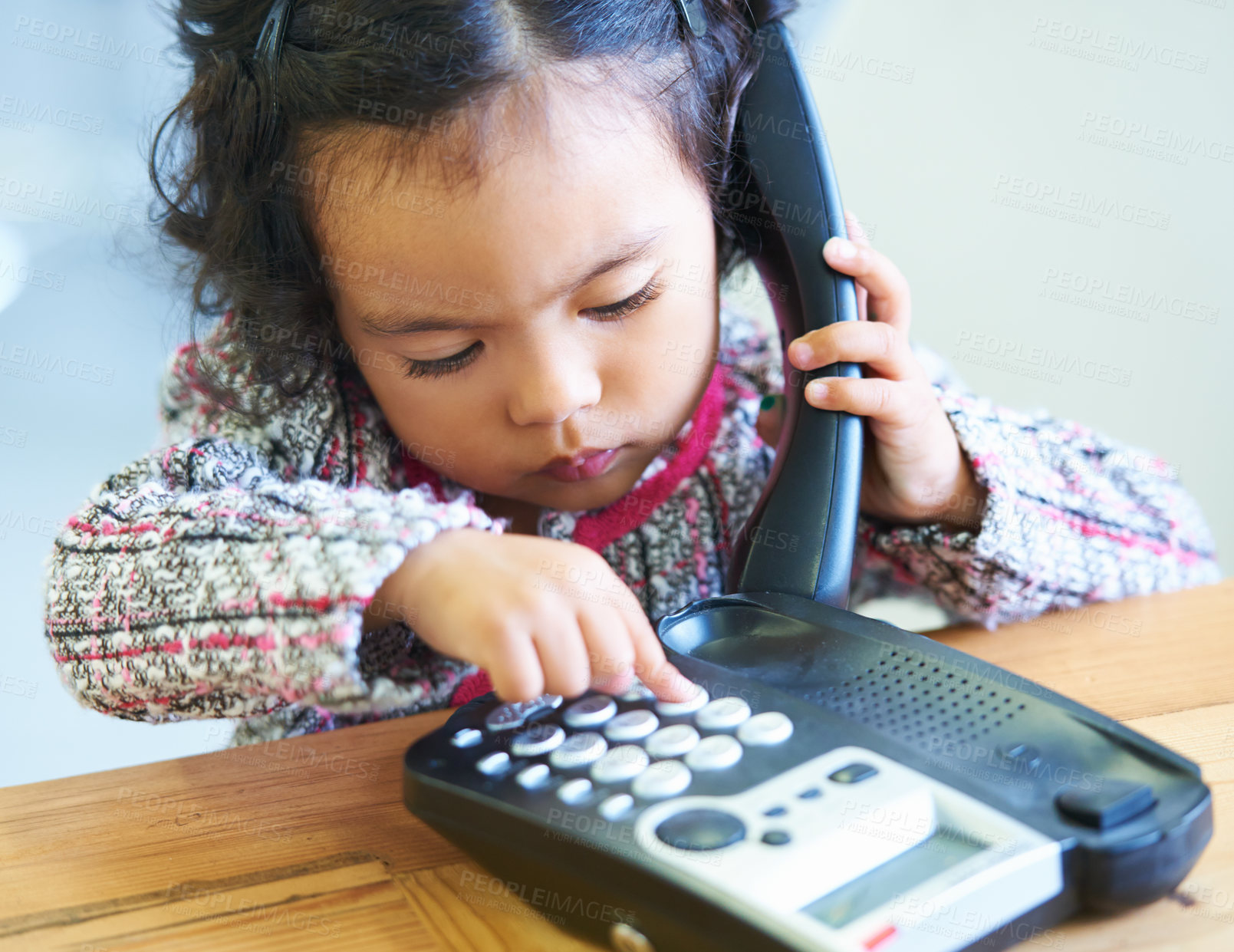 Buy stock photo Playing, dial and a child on a telephone phone call for communication in a house. Home, contact and a girl, kid or baby speaking on a landline for conversation, play or a discussion at a desk