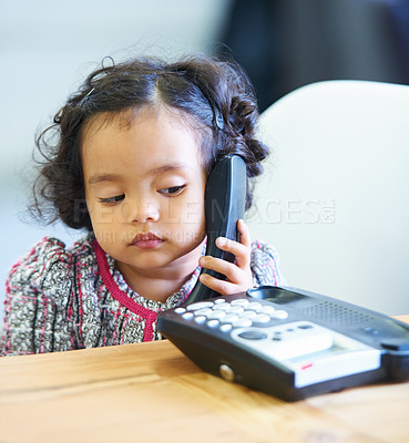 Buy stock photo Listening, talking and a child on a telephone phone call for communication in a house. Home, contact and a girl, kid or baby speaking on a landline for conversation, play or a discussion at a desk