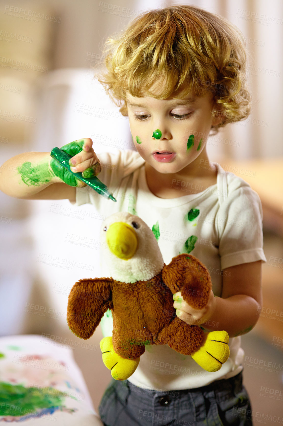 Buy stock photo Shot of an adorable little boy making a mess while painting