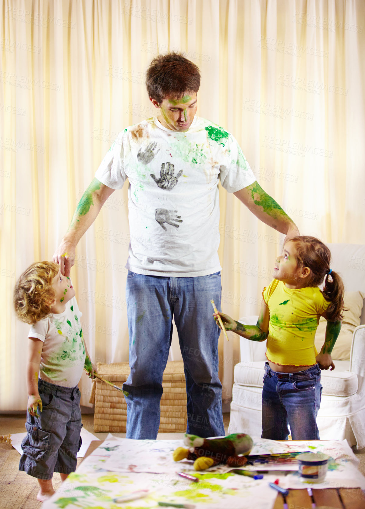 Buy stock photo Shot of a paint covered father scolding his children for making a mess
