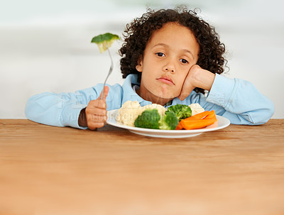 Buy stock photo Bored, upset and child eating vegetables for a healthy, growth and wellness diet at his home. Nutrition, dinner and sad boy kid at the dining table with produce lunch, snack or meal at his house.