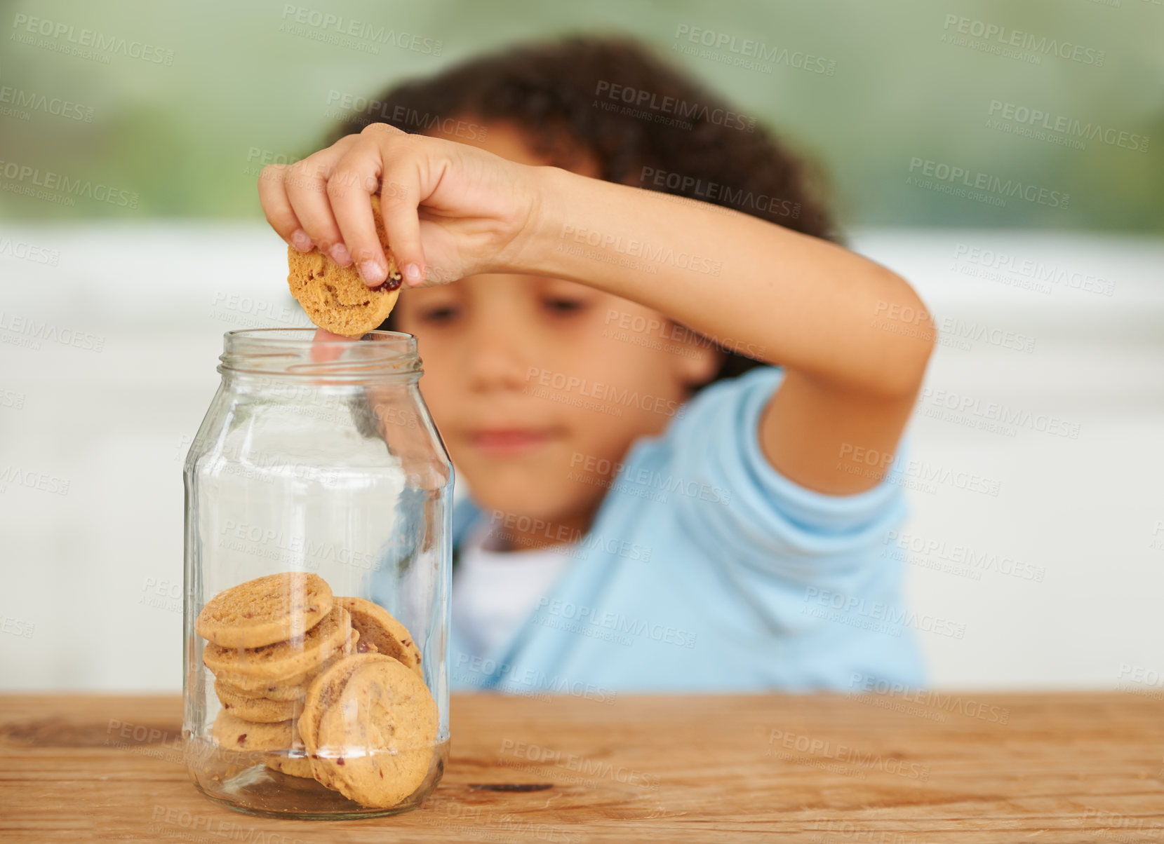 Buy stock photo Craving, cookie jar and boy child by the kitchen counter eating a sweet snack or treat at home. Smile, dessert and cute hungry young kid enjoying biscuits by a wooden table in a modern family house.