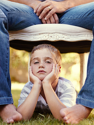 Buy stock photo Bored, face and portrait of child with parent lying on grass for bonding, support and love in outdoor park together. Care, chair and young kid with father or dad on vacation or holiday travel