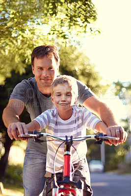 Buy stock photo Shot of a father and son spending quality time together with a bicycle 