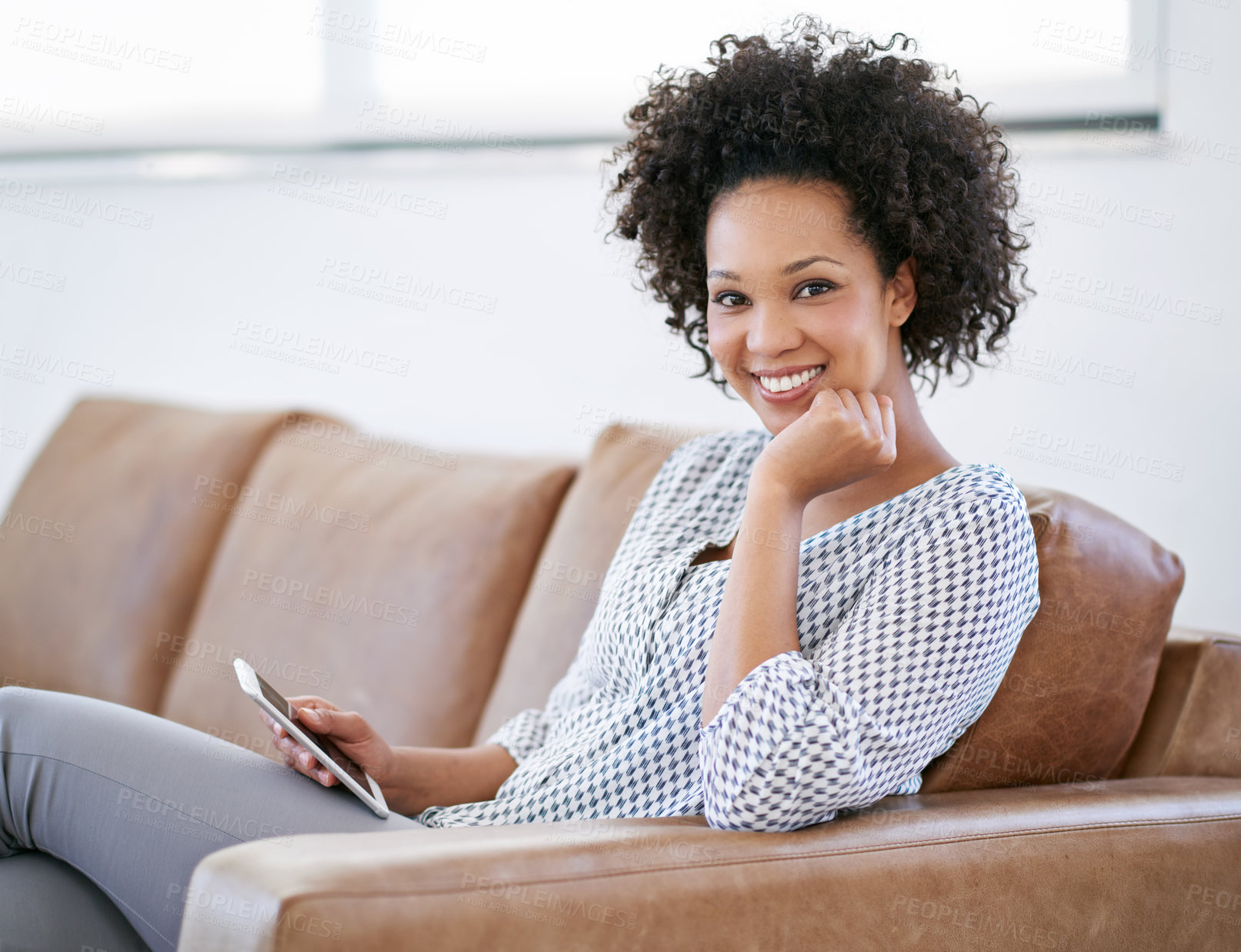 Buy stock photo Portrait of an attractive woman sitting on the sofa with her smartphone