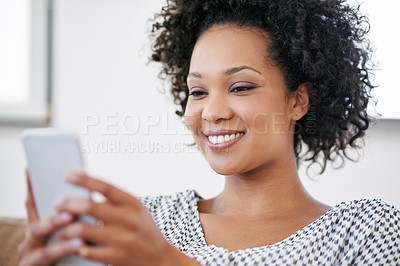 Buy stock photo Shot of an attractive woman using her smartphone at home