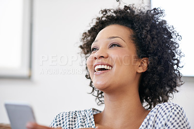 Buy stock photo Shot of an attractive woman laughing while sitting with her smartphone at home