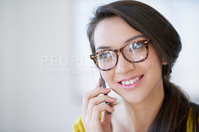 Buy stock photo Shot of an attractive young woman talking on a cellphone in an office