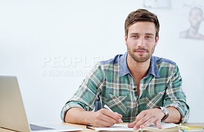 Buy stock photo Portrait of a casually-dressed young man using a digital tablet at his desk. The commercial designs displayed  represent a simulation of a real product and have been changed or altered enough by our team of retouching and design specialists so that they don't have copyright infringements