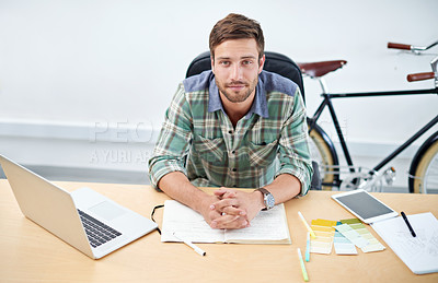 Buy stock photo Portrait of a casually-dressed young man using a digital tablet at his desk