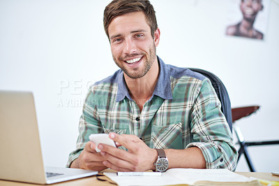 Buy stock photo Portrait of a casually-dressed young man using a digital tablet at his desk. The commercial designs displayed  represent a simulation of a real product and have been changed or altered enough by our team of retouching and design specialists so that they don't have copyright infringements