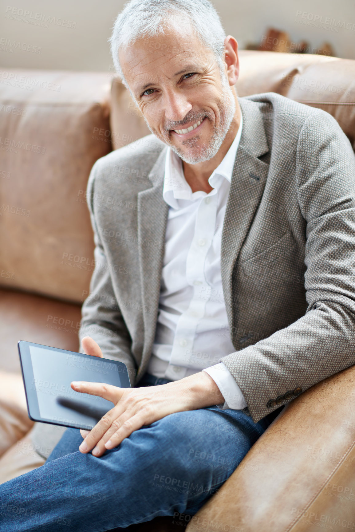 Buy stock photo Portrait of a handsome mature man sitting on the sofa with his digital tablet