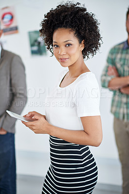 Buy stock photo Portrait of an attractive young businesswoman using a digital tablet with her colleagues in the background. The commercial designs displayed  represent a simulation of a real product and have been changed or altered enough by our team of retouching and design specialists so that they don't have copyright infringements