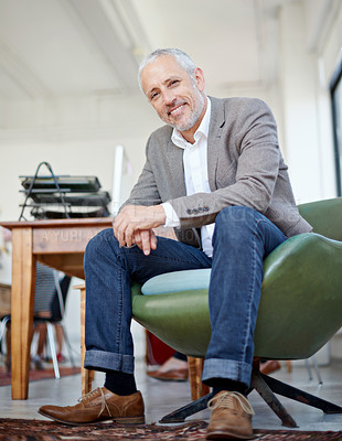 Buy stock photo Portrait of a mature businessman sitting in a chair in an office