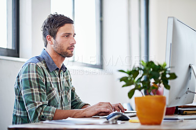 Buy stock photo Shot of a young designer working on a computer in an office