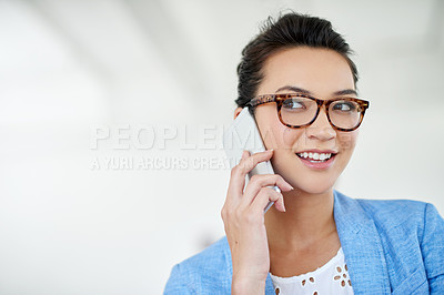 Buy stock photo Shot of an attractive young woman talking on a cellphone in an office