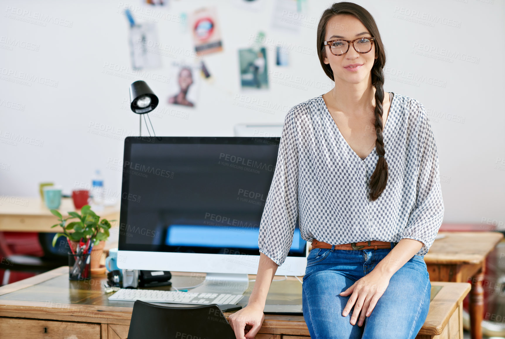 Buy stock photo Portrait of a beautiful young woman working in a modern office. The commercial designs displayed represent a simulation of a real product and have been changed or altered enough by our team of retouching and design specialists so that they don't have copyright infringements