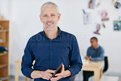 Buy stock photo Portrait of a handsome businessman using a digital tablet in the office. The commercial designs displayed  represent a simulation of a real product and have been changed or altered enough by our team of retouching and design specialists so that they don't have copyright infringements