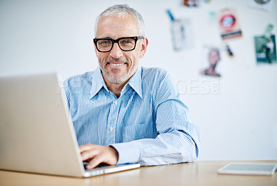 Buy stock photo Portrait of a handsome businessman working on his laptop. The commercial designs displayed represent a simulation of a real product and have been changed or altered enough by our team of retouching and design specialists so that they don't have copyright infringements