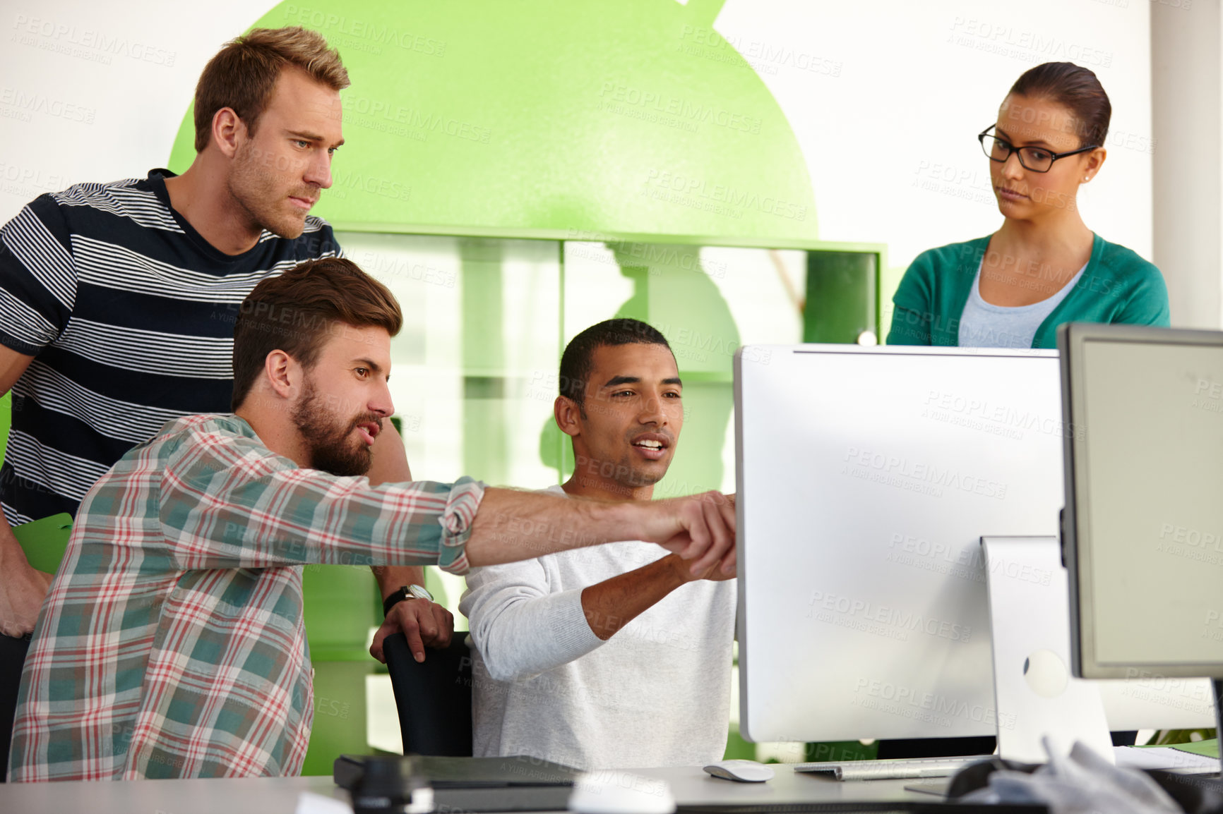 Buy stock photo Shot of a group of young designers working together at a computer