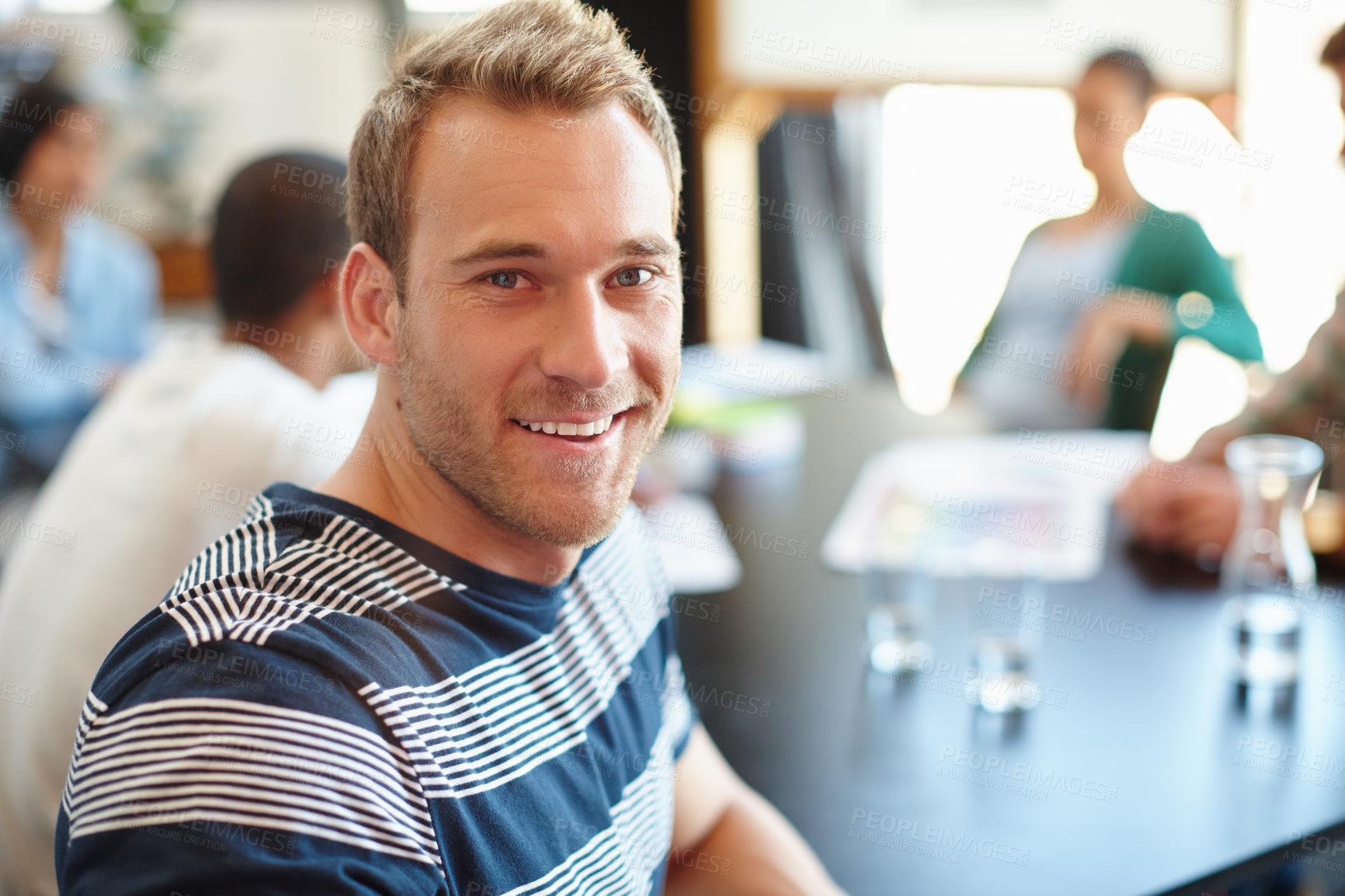 Buy stock photo Portrait of a male designer in a meeting with his colleagues in the background