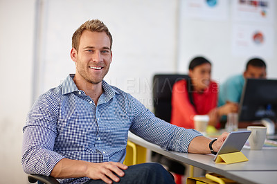 Buy stock photo Portrait of a young male designer sitting at his desk with his tablet
