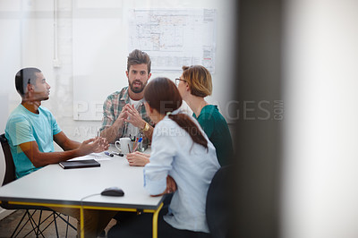Buy stock photo Shot of a group of young designers discussing work in a meeting