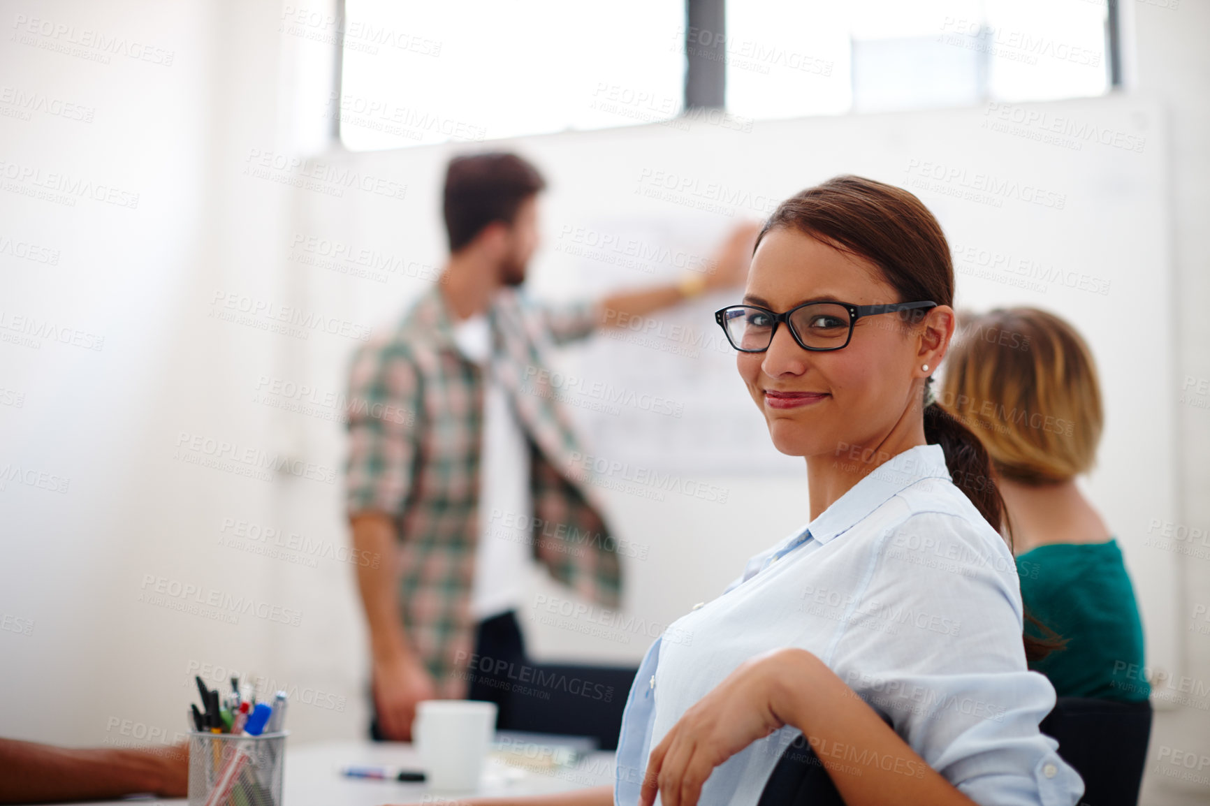 Buy stock photo Portrait of a young female designer in a meeting with her colleagues