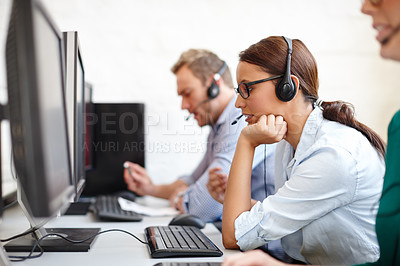 Buy stock photo Shot of a sales support team taking calls at their computers