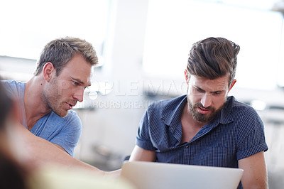 Buy stock photo Shot of two male designers working together at a laptop