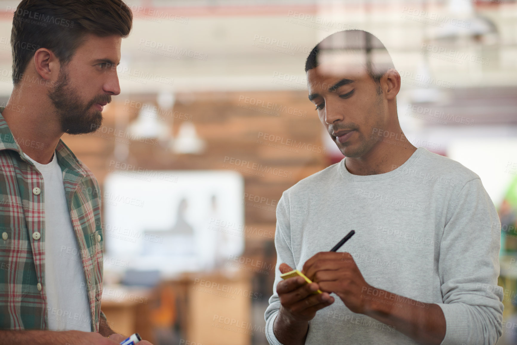 Buy stock photo Shot of two colleagues discussing ideas together
