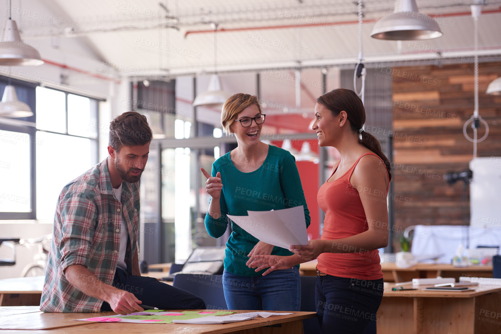 Buy stock photo Shot of a group of young creatives talking around a table