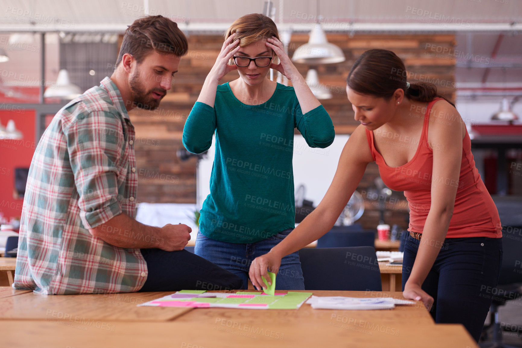 Buy stock photo Shot of a group of young creatives talking around a table