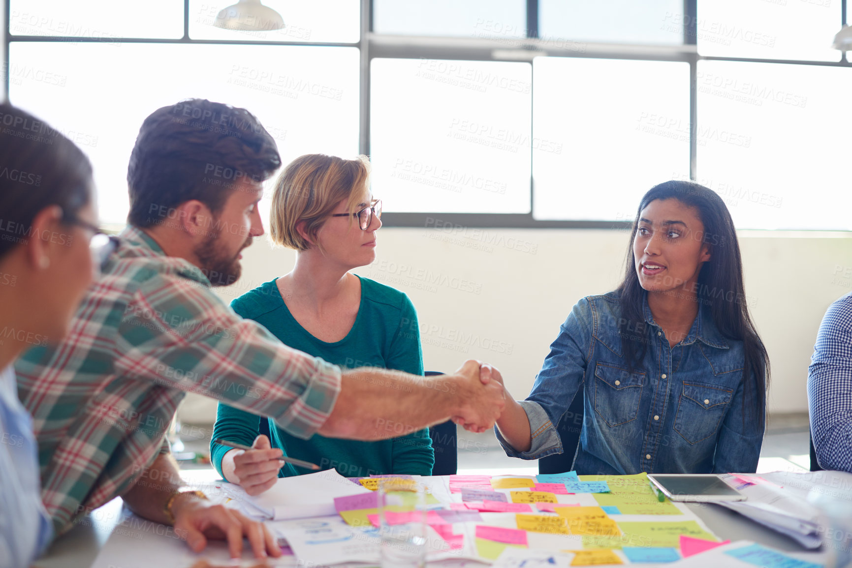 Buy stock photo Man, woman and handshake in meeting at startup for agreement, welcome and b2b collaboration at company. People, group and shaking hands with thank you, diversity and documents at creative agency