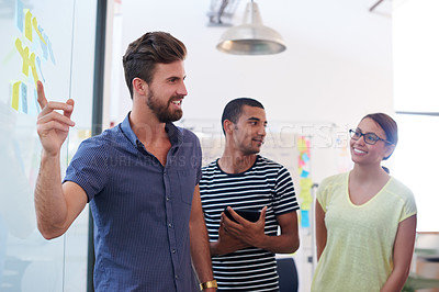 Buy stock photo Brainstorming, people or pointing to ideas on glass wall in startup for collaboration, talking or teamwork. Meeting, creative or designers in discussion for solution, sticky note or project in agency