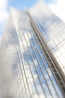 Buy stock photo Blurry, building and window of tower in city with reflection of blue sky and clouds on glass. Urban, office and architecture of skyscraper or hotel with trippy motion for vertigo from heights in town