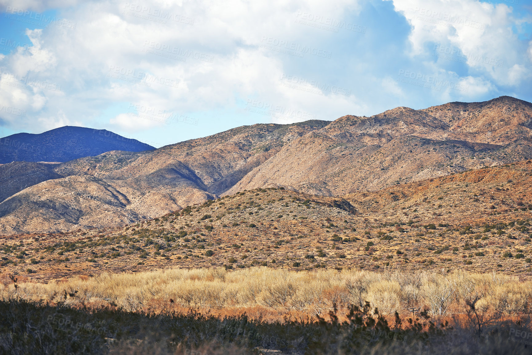 Buy stock photo Landscape, sustainable and mountains in nature for agriculture, eco friendly and agro environment. Outdoor, travel and dry habitat with grass, blue sky and clouds for natural hiking trail by rocks.