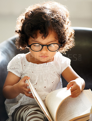 Buy stock photo Baby, sofa and a child reading a book for education, learning and knowledge in a house. Morning, smart and a girl, kid or toddler with a story and glasses for studying or childhood on the couch